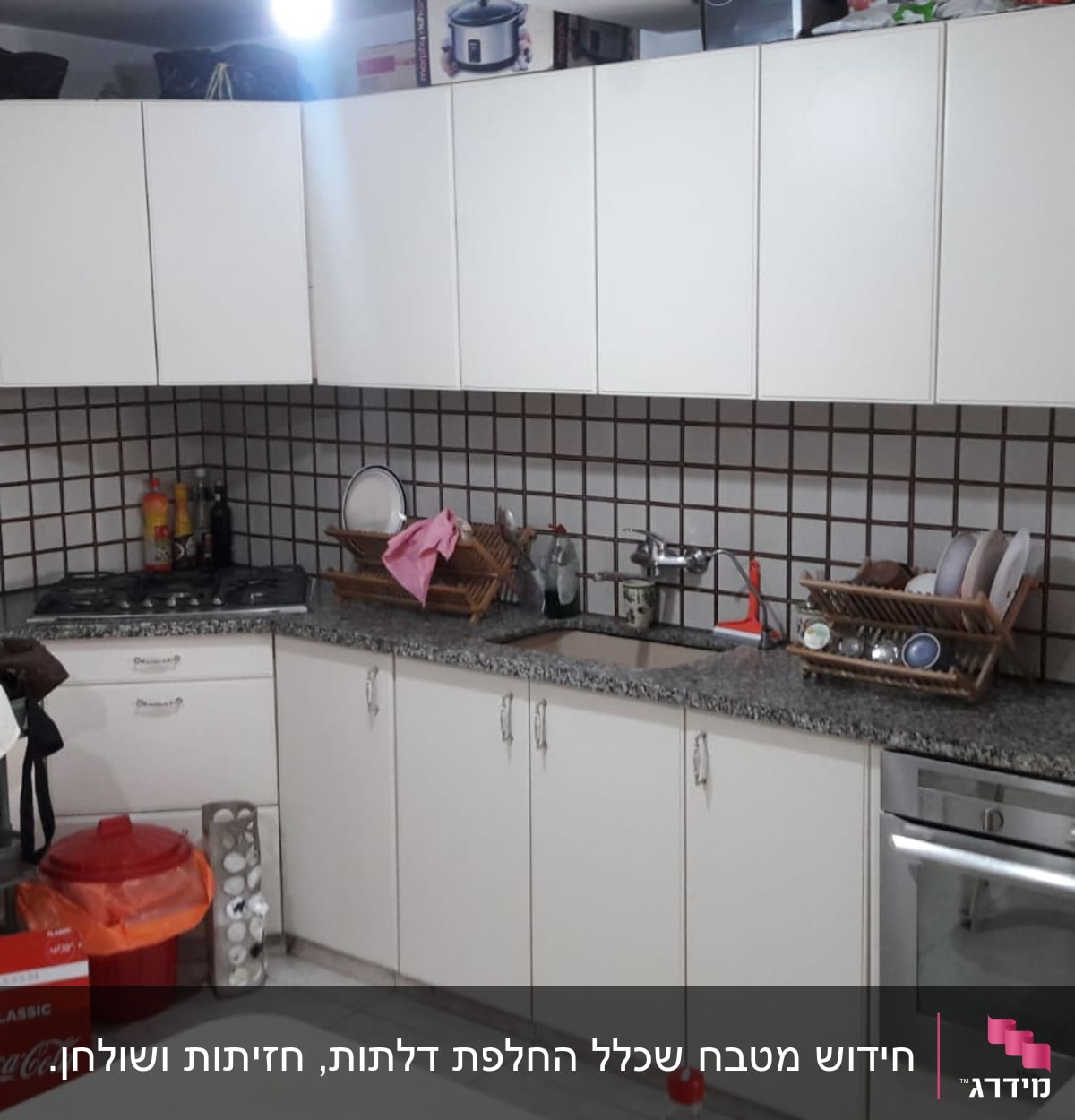 מטבח עם ארונות לבנים, כיור, ותנור אפייה